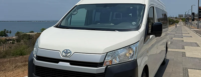 White 16-seat Toyota HiAce from Costa Phoebe's own fleet, on the Luanda seafront
